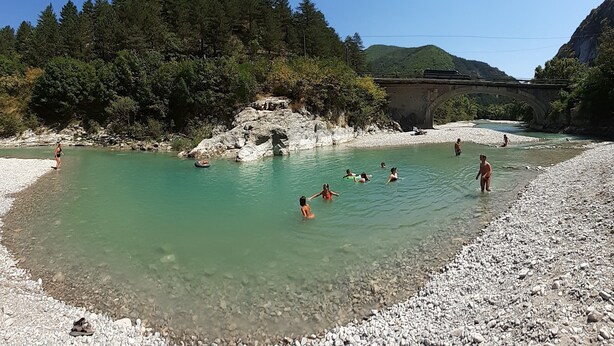 A river with clear water, surrounded by rocky terrain and dense forest. - Gite la Rose des Alpes (Serres)