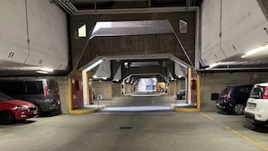 A parking garage with multiple levels, concrete floors, and marked parking spaces. - Bnbook Residenza Balzarotti 1 (RHO)