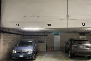 Uma garagem de estacionamento com dois carros estacionados em vagas adjacentes, numeradas 13 e 14.