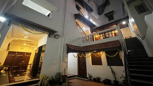 A multi-story building with a balcony, a staircase, and a well-lit entrance. - Villa Vedapuri (Puducherry)