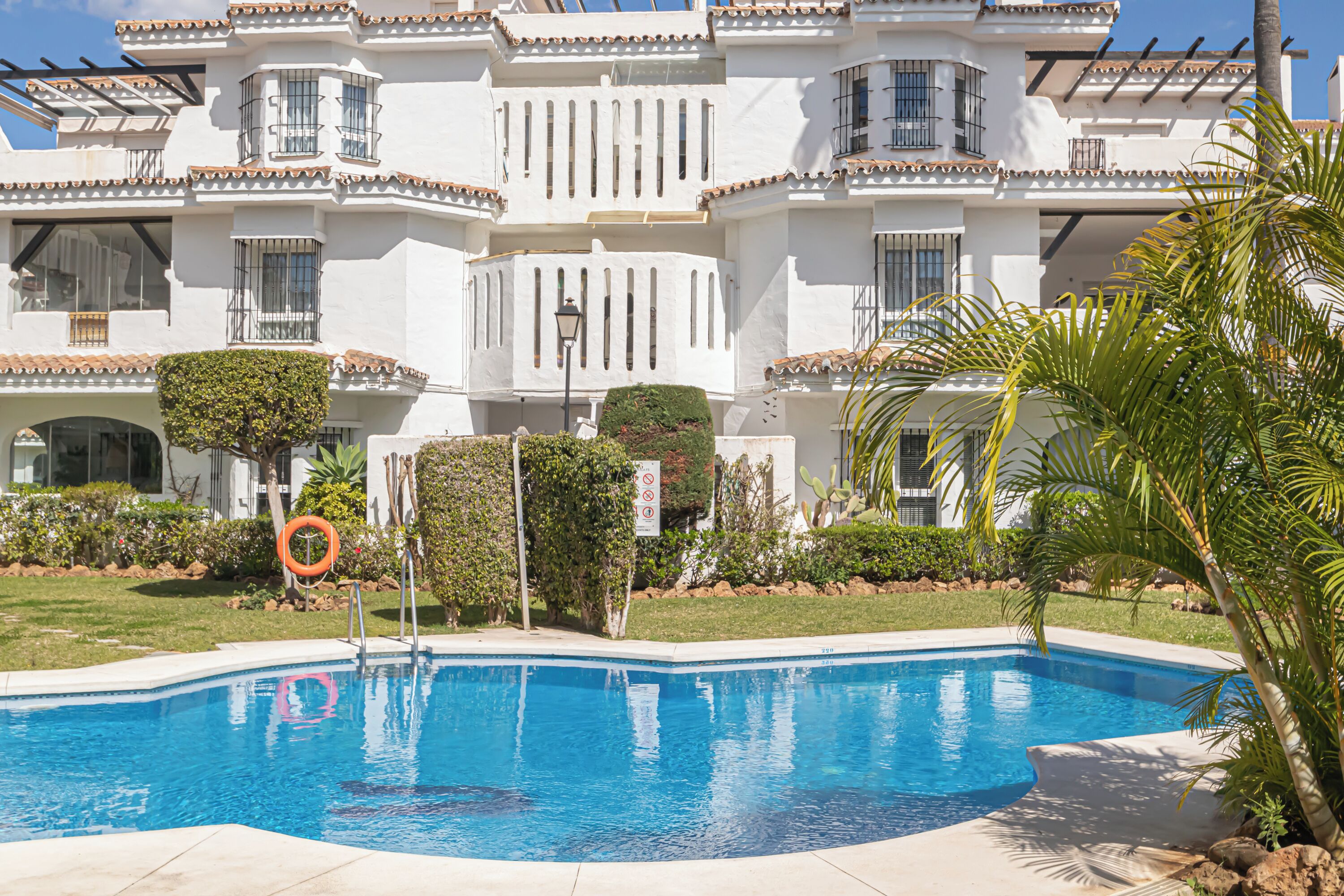 A swimming pool with a white building in the background.