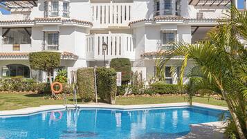 A swimming pool with a white building in the background.