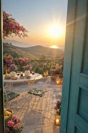 A terrace with a table set for dining, surrounded by potted plants and candles, overlooking a scenic landscape. - FİNTOZ BUTİKA (Karaburun)