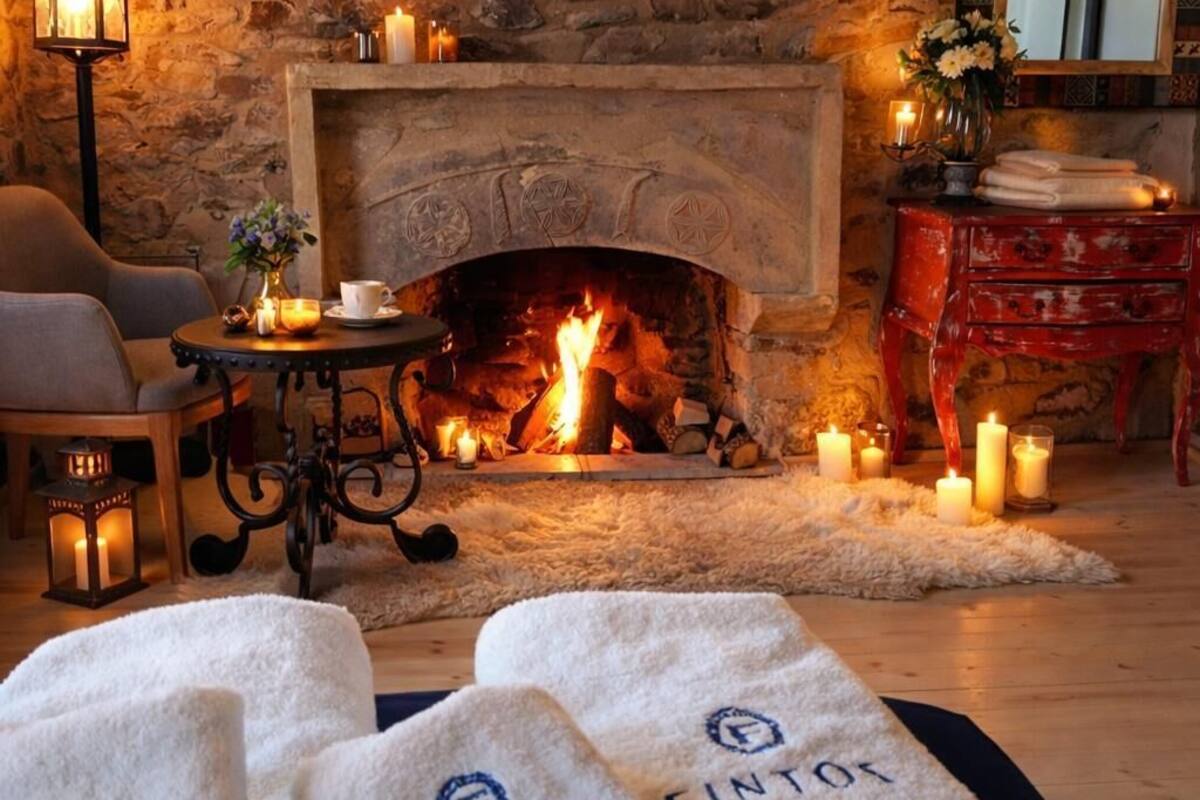 A cozy room with a stone fireplace, candles, and a red dresser.