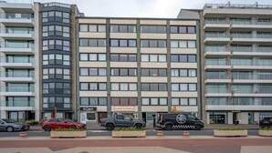Un edificio de varios pisos con un diseño arquitectónico moderno, que combina fachadas de vidrio y hormigón.