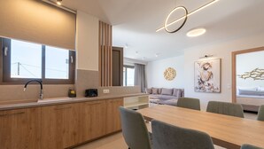 Een moderne keuken met een houten aanrecht, een spoelbak en een eethoek met een tafel en stoelen.