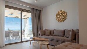 Een moderne woonkamer met een bank, een salontafel en een eethoek met stoelen.
