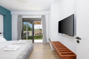 Un dormitorio moderno con cama, televisor montado en la pared y puerta corrediza de vidrio que da a un área exterior.