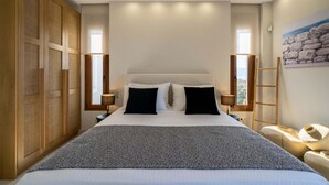 Un dormitorio con una cama grande, un armario de madera y un cuadro en la pared.
