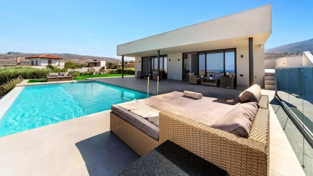 A modern house with a swimming pool, outdoor seating, and a view of the sea. - Villa in Gournes with Private Pool & Sea Views (Heraklion)
