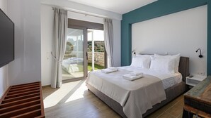 A modern bedroom with a large bed, a TV, and a sliding glass door leading to an outdoor area. - Scenic villa in Rethymno with private pool (Rethymno)