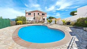 A two-story house with a swimming pool, stone patio, and outdoor furniture. - Villa in Lloret de Mar with Private Pool (Lloret de Mar)