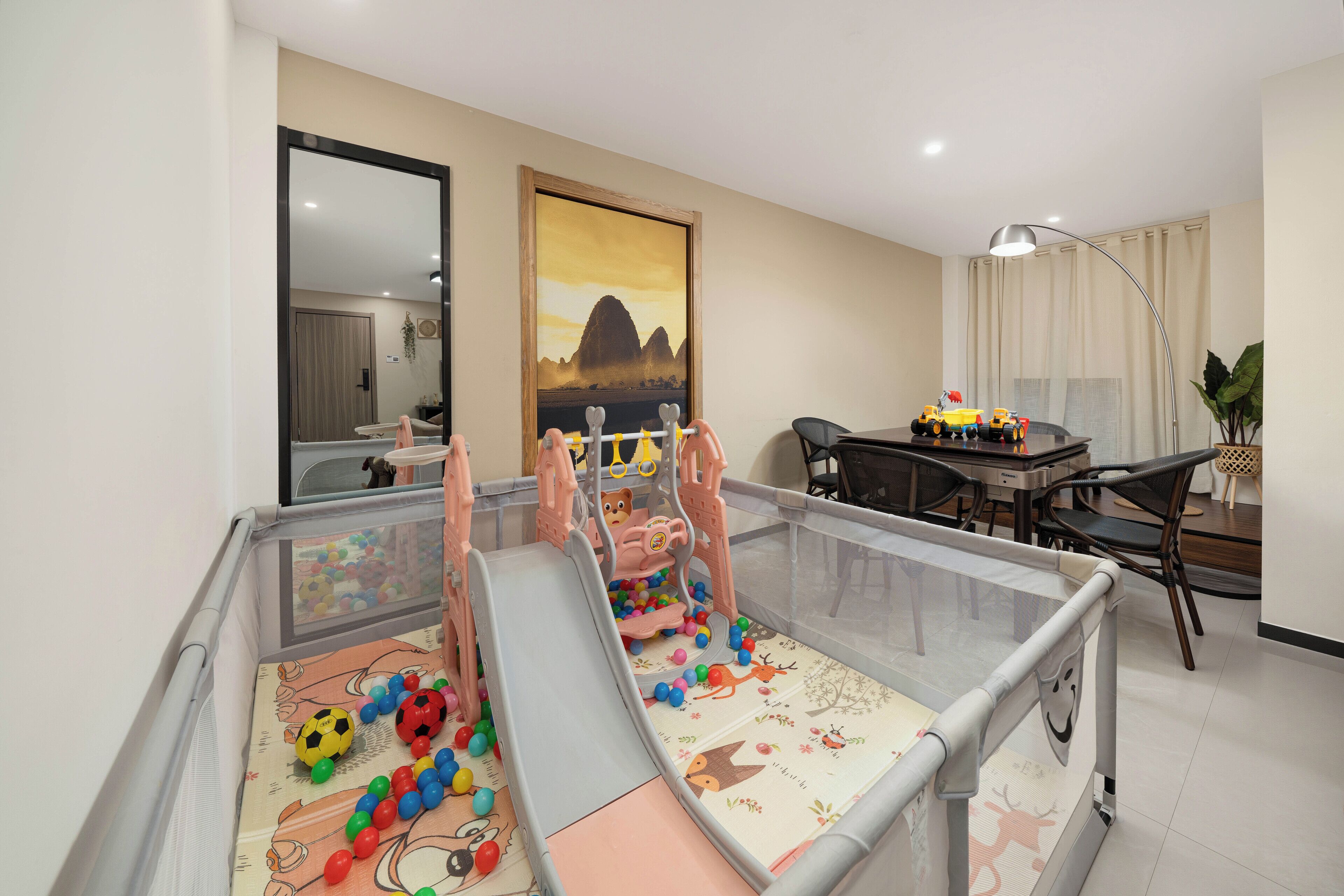 Un espace de jeux avec un toboggan, une piscine à balles et une table remplie de jouets.