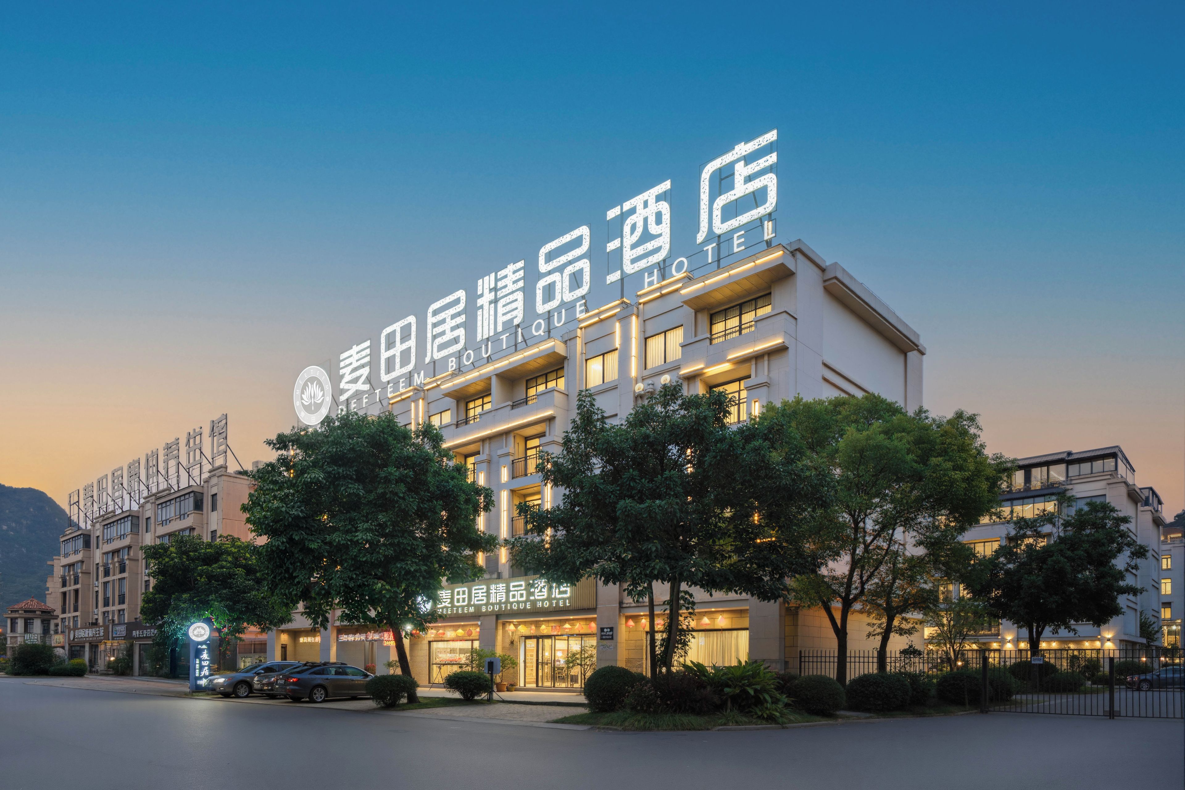 A hotel with a modern facade, multiple floors, and a prominent sign.