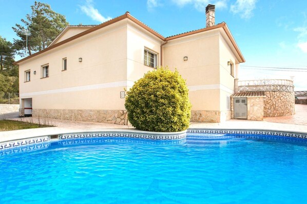 Ein zweistöckiges Haus mit einem Schwimmbad davor.