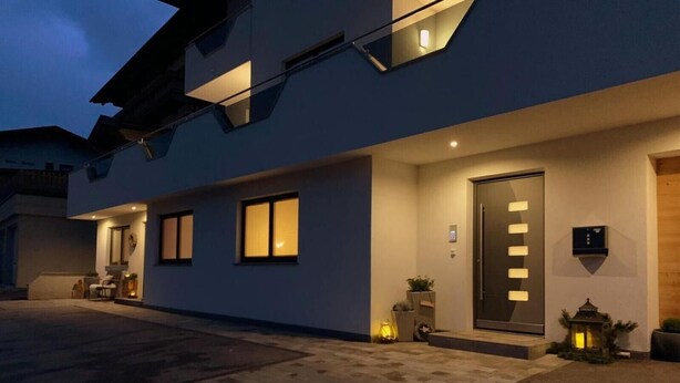 A modern building with a flat roof, large windows, and a door with a light panel. - Apartment 'Mario' with Mountain View, Private Terrace and Wi-Fi (Hippach)