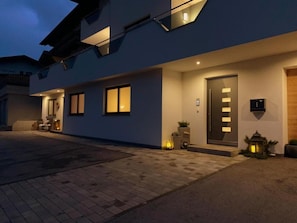 A modern building with a flat roof, large windows, and a door with a light panel. - Apartment 'Mario' with Mountain View, Private Terrace and Wi-Fi (Hippach)