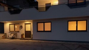 A modern two-story house with a balcony, large windows, and a door with a wreath. - Apartment 'Mario' with Mountain View, Private Terrace and Wi-Fi (Hippach)