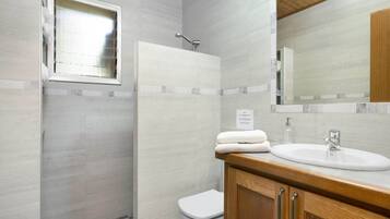 Un baño con ducha, inodoro y lavamanos.