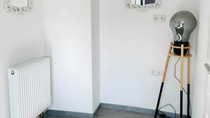 A room with a radiator, two ornate mirrors, a light bulb on a wooden stand, and a power outlet. - Apartment 'D Haus' with Wi-Fi (Arnstein)