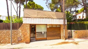 A small building with a stone facade, a wooden door, and a covered entrance.