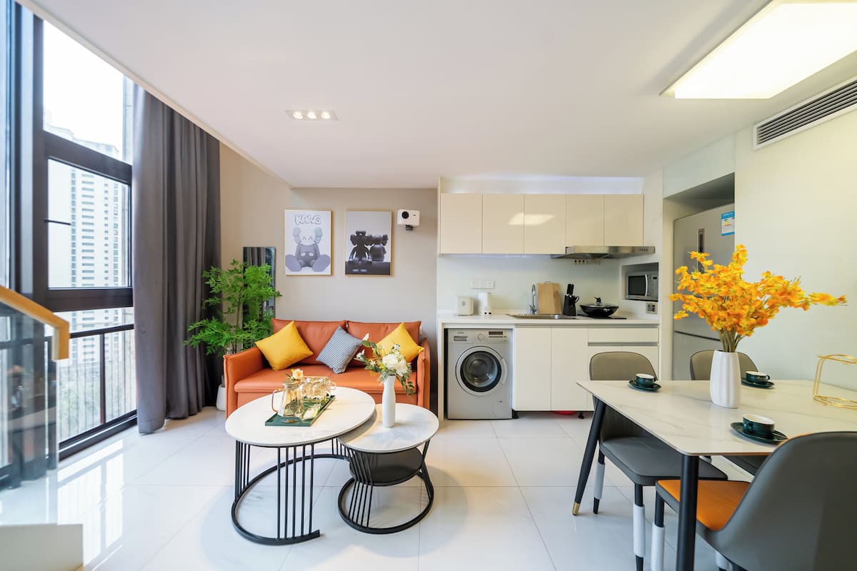 A modern apartment with a living area, kitchen, and dining space.