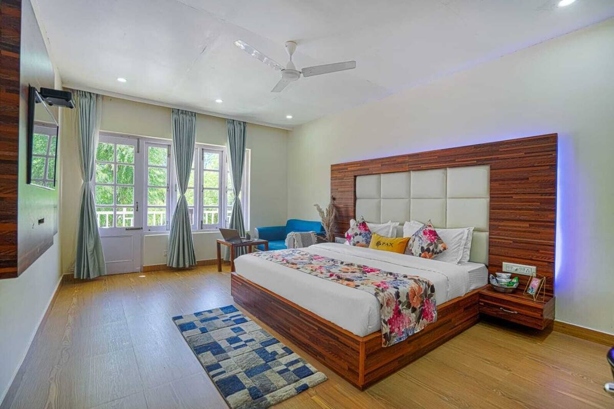 Un dormitorio con una cama grande, un ventilador de techo, un escritorio y una silla.
