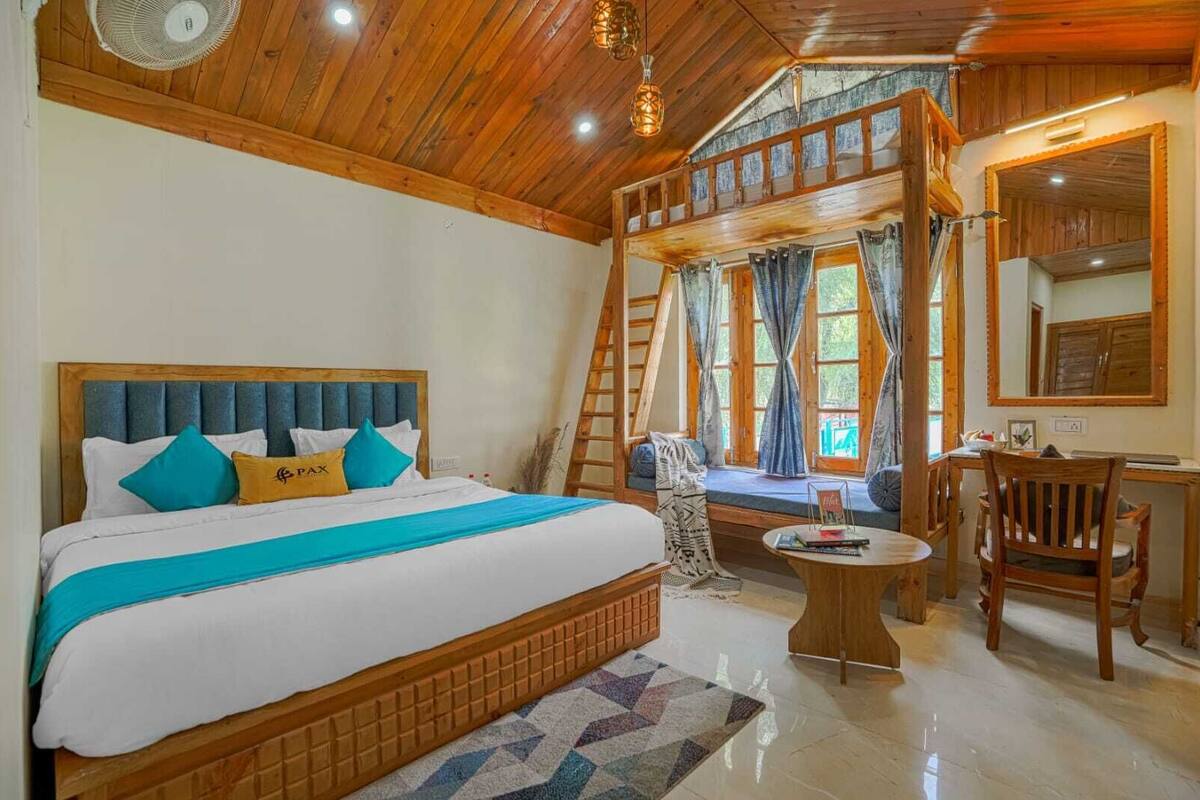 Un dormitorio estilo cabaña de madera con una cama grande, un escritorio y una silla.