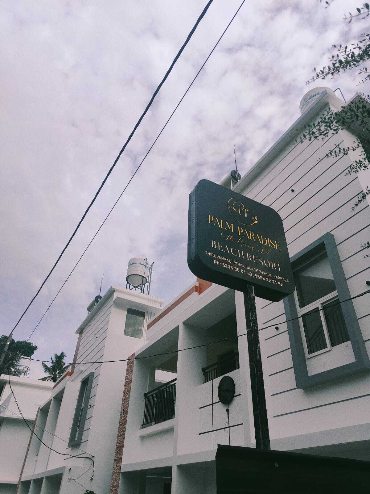 A sign for Palm Paradise Resort, indicating its name and address.