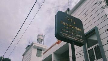 A sign for Palm Paradise Resort, indicating its name and address.