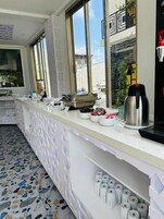 A kitchen counter with a coffee machine, a food warmer, and various kitchen utensils.