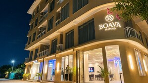 Un edificio de varios pisos con un letrero que dice 'BOAVA SEAFOOD', indicando un restaurante de mariscos.
