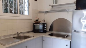 Una cocina moderna con un refrigerador de acero inoxidable, un microondas y un lavamanos.