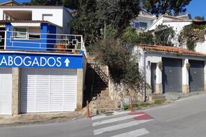 Un edificio con un letrero azul que dice "ABOGADOS" y una escalera que lleva a un garaje.