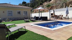 A backyard with a swimming pool, outdoor furniture, and a covered patio area. - Villa on Costa Brava with Pool & Sea Views (Lloret de Mar)