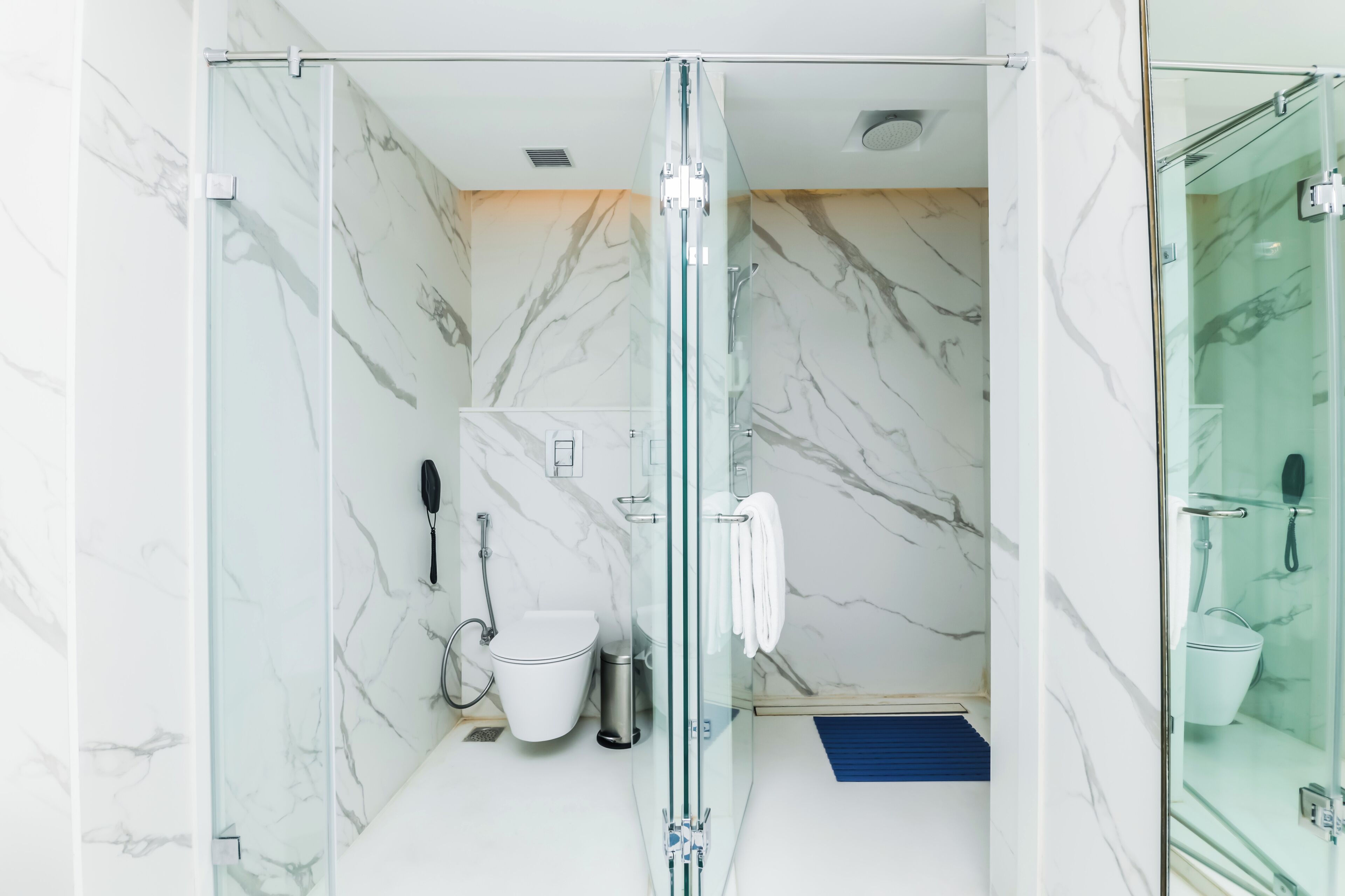 Een moderne badkamer met een douchecabine van glas, een toilet en een bidet.