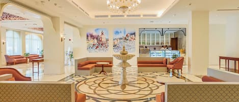 A spacious lobby with a central fountain, seating areas, and artwork on the walls.