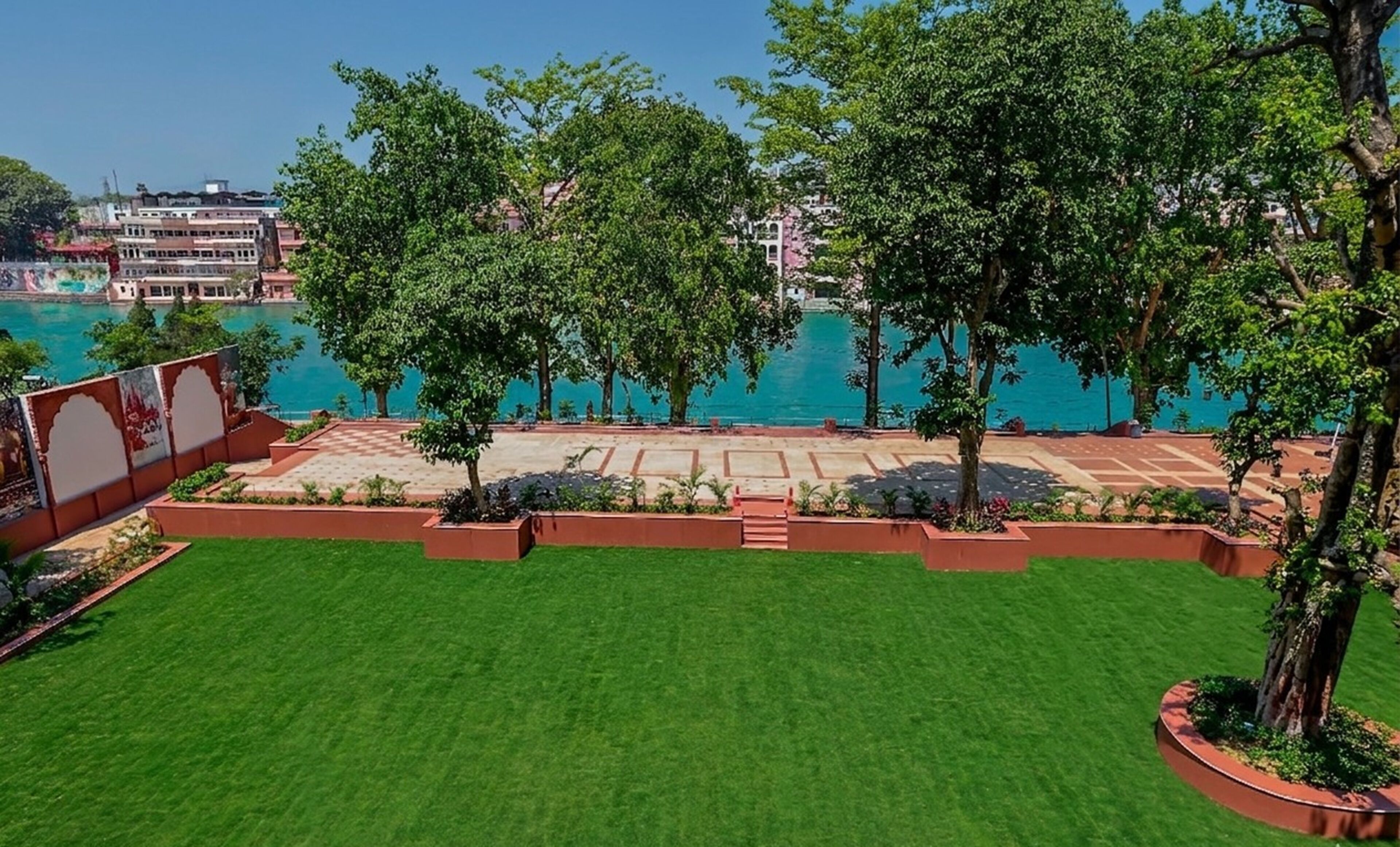 A well-maintained lawn, trees, and a view of a body of water.