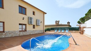 A swimming pool with a metal ladder, surrounded by a tiled patio. - Apartment in Blanes with Sea View Terrace (Blanes)