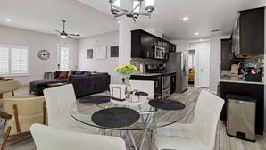 A modern kitchen with dark cabinets, a stainless steel refrigerator, and a microwave.