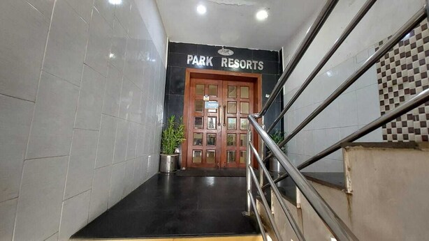 Un escalier menant à une porte portant l’inscription « PARK RESORTS », avec un pot de fleurs placé à côté.