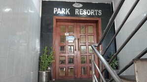 Une porte à deux battants en bois, avec une enseigne au-dessus indiquant « PARK RESORTS ».