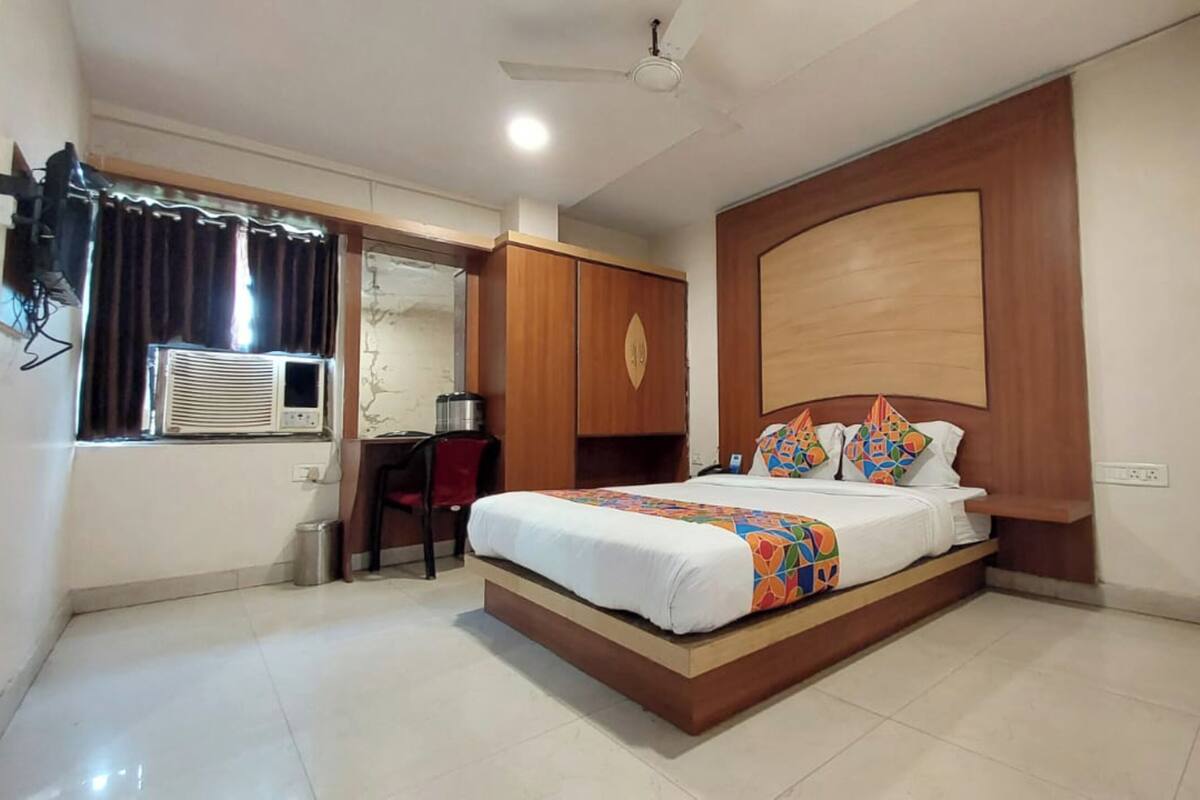 Una camera d'albergo con un letto grande, una scrivania e un armadio.