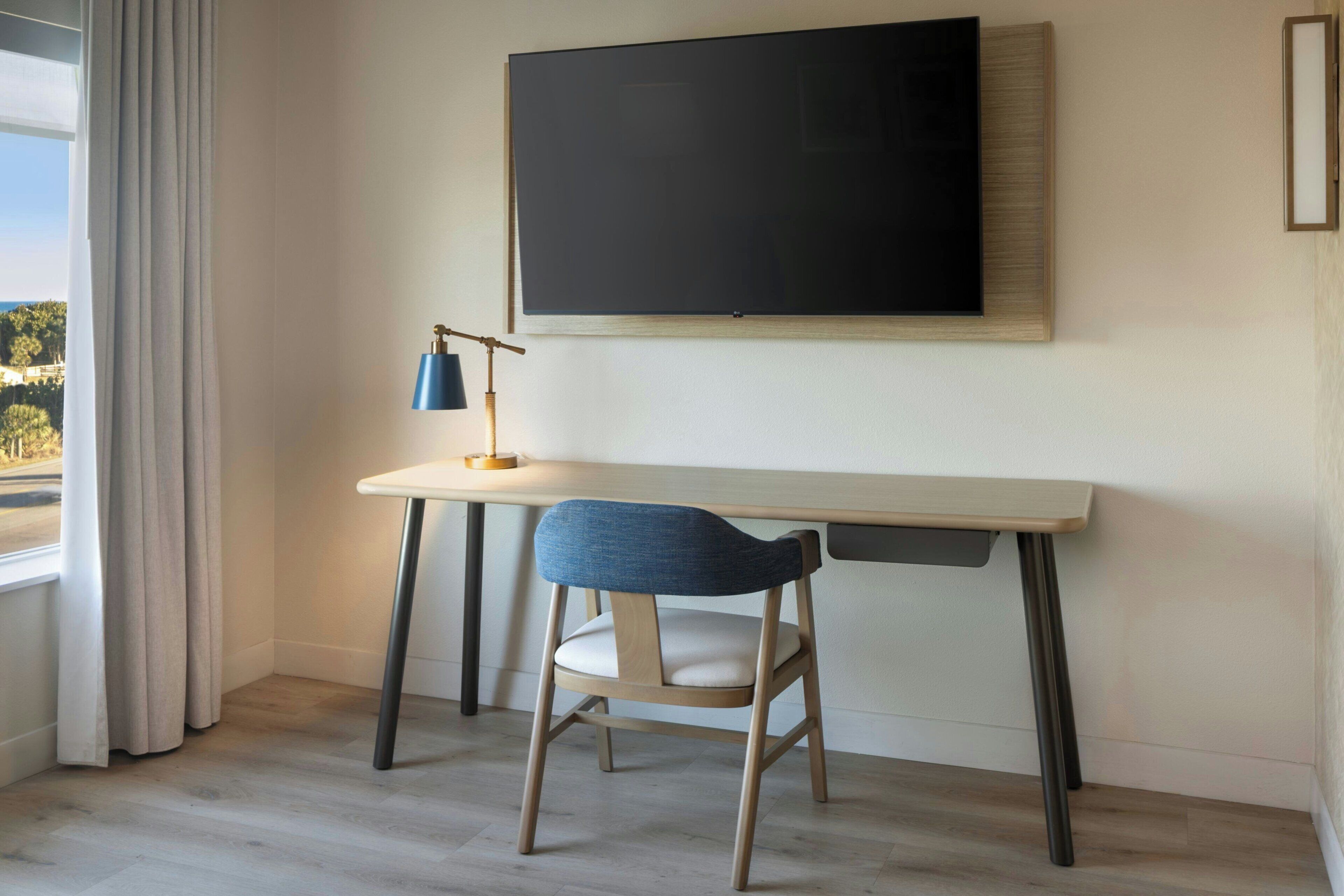 Una habitación moderna con escritorio, silla y una pizarra grande.