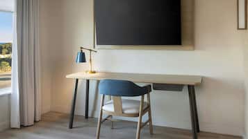 Una habitación moderna con escritorio, silla y una pizarra grande.