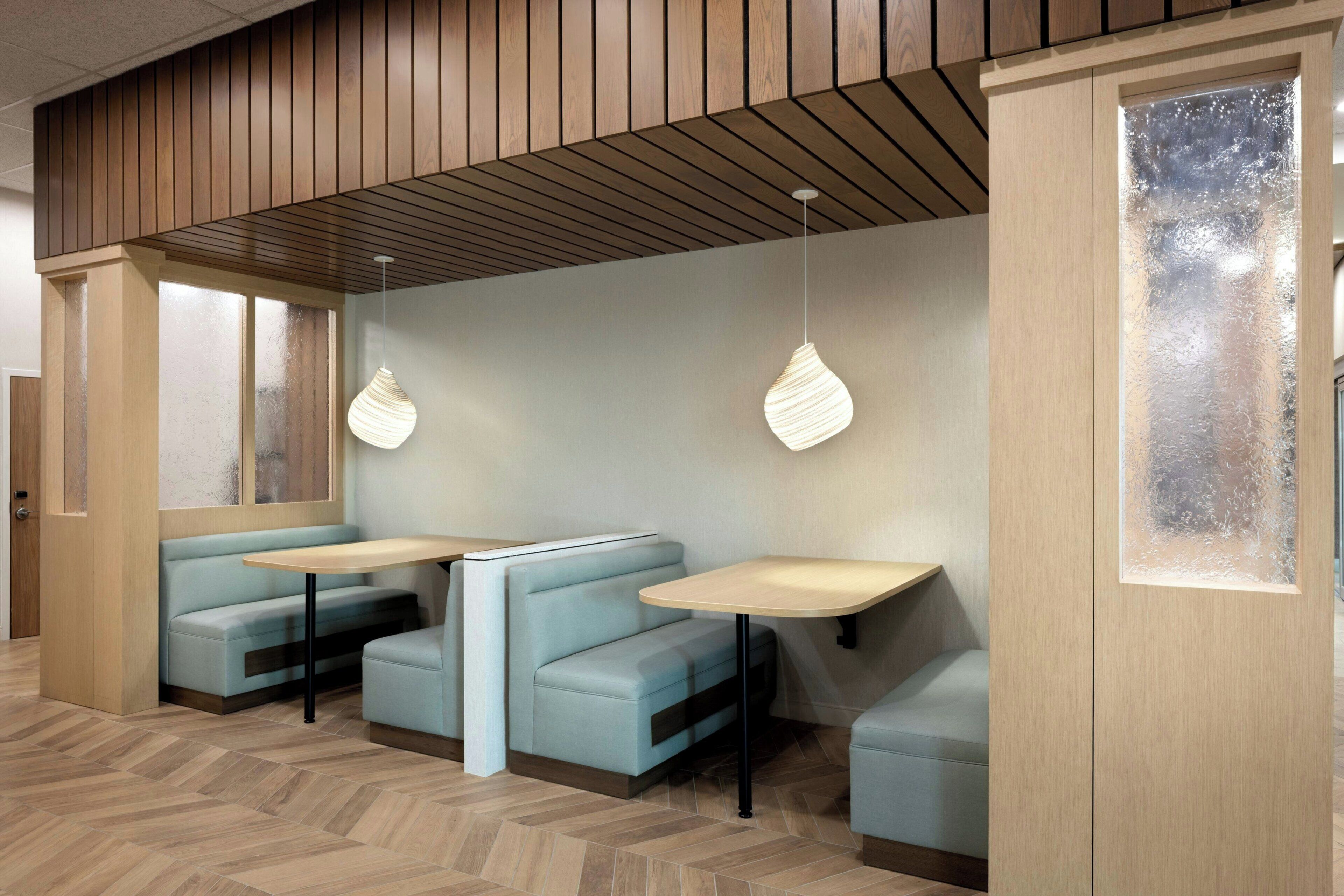 Un intérieur moderne avec des espaces aménagés pour s’asseoir et des luminaires suspendus.