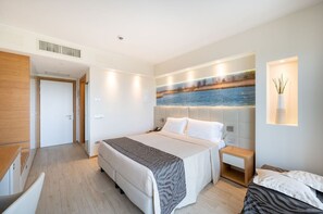 Ein modernes Hotelzimmer mit einem großen Bett, einem Nachttisch und einer Wandlampe.