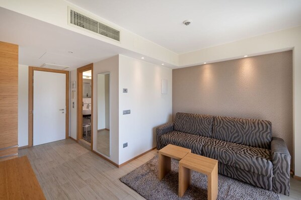A modern living room with a sofa, a coffee table, and a mirror.