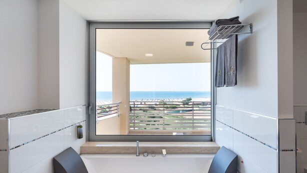 Ein modernes Badezimmer mit großem Fenster, einer Badewanne und einer Duschkabine.
