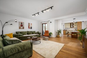 A modern living room with a sofa set, a coffee table, and a dining area with a table and chairs. - Luxury Villa Sofia | Private Pool & Garage (Porec)